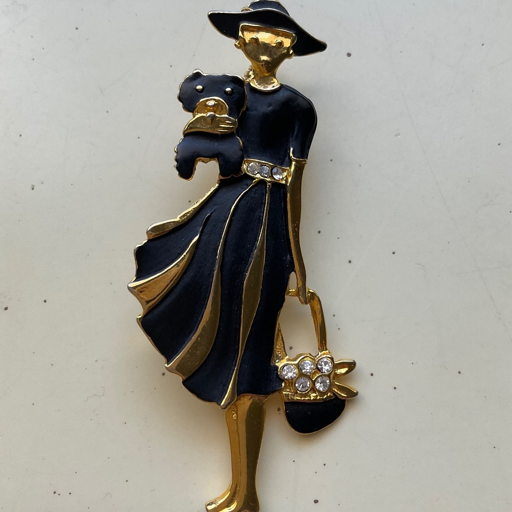 Vintage women holding dog brooch, black and gold.